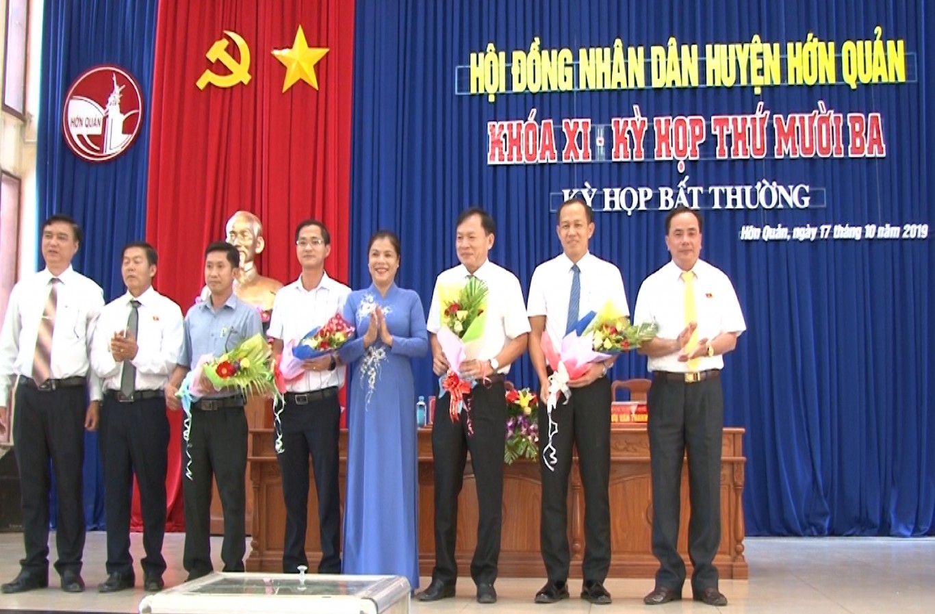Bí thư Huyện ủy Nguyễn Thị Xuân Hòa, tặng hoa chúc mừng Phó chủ tịch UBND huyện đứng thứ 3 từ phải qua (áo trắng kế bí thư) và các thành viên UBND huyện