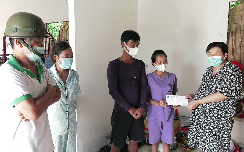 Đại diện UBMTTQ huyện Hớn Quản trao tặng tiền hỗ trợ gia đình anh Huỳnh Tẩu Nam đi tái khám cho cháu bé. 
