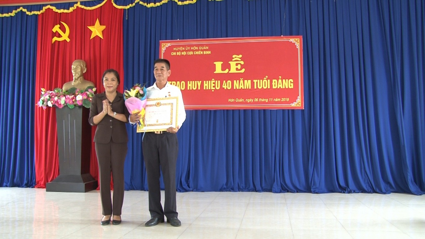 Đồng chí Nguyễn Thị Xuân Hòa, Bí thư Huyện ủy trao huy hiệu 40 năm tuổi đảng cho đồng chí Phạm Quốc Vượng
