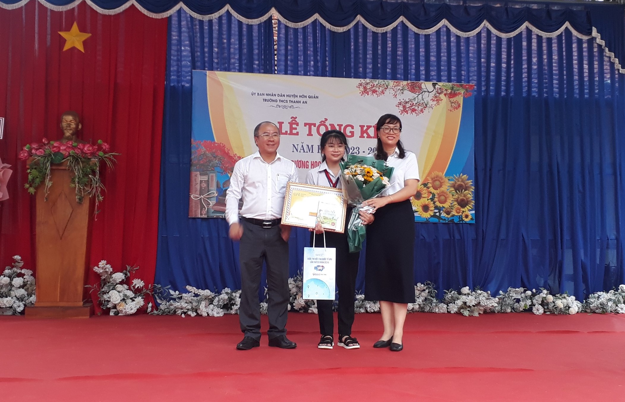 Ông Nguyễn Minh Quang - Giám đốc Sở Thông tin và Truyền thông, bà Huỳnh Như Quỳnh - Giám đốc Bưu điện tỉnh trao thưởng cho em Đỗ Thiên Kim.